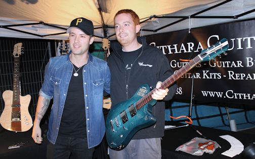 Performer Dallas Smith (L) poses with Daniel Clark of Cithara Guitars, after signing a guitar at Music in the Fields Friday night; the guitar was signed by all of the event's peformers and raffled off Saturday night